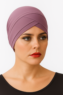 A person wearing a stylish, lavender headscarf with a sleek design and a black top, set against a plain white background.